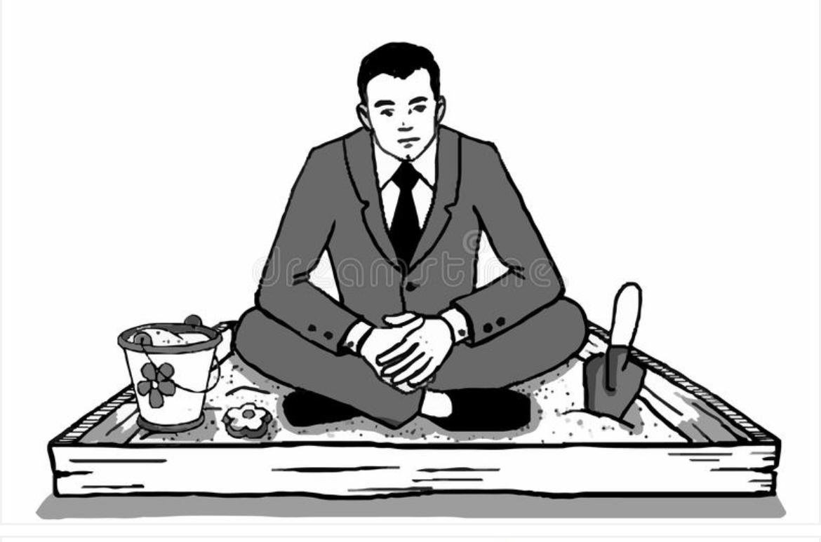 Man in suit sitting in sandbox