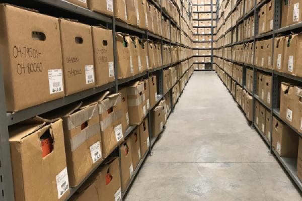 Photo of stacks of archived records on multiple shelving units